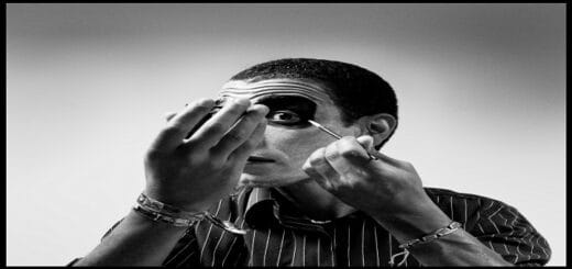 Una persona en blanco y negro se aplica maquillaje oscuro, en una metáfora del poema "Te he visto" y de ver el verdadero rostro de alguien.